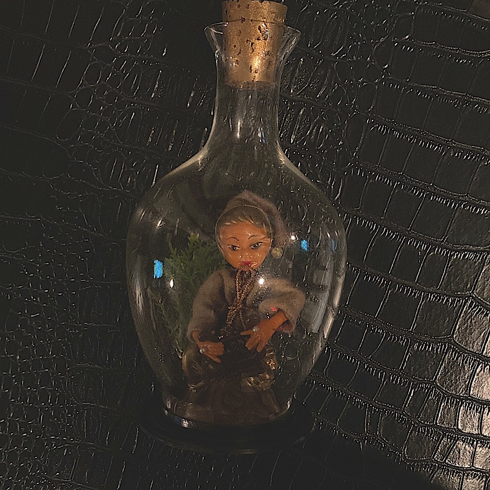 This is a vintage mid century golden pixie elf Playing a harp in a bell jar.